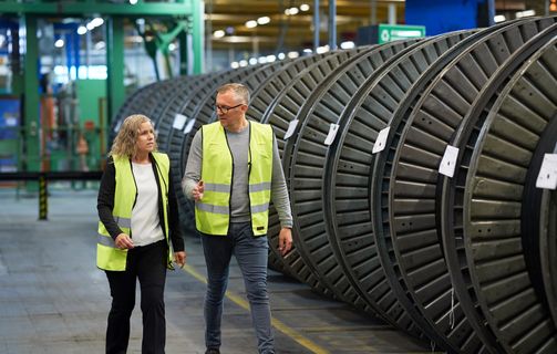 employees discussing and talking in production hall in front of cable drums